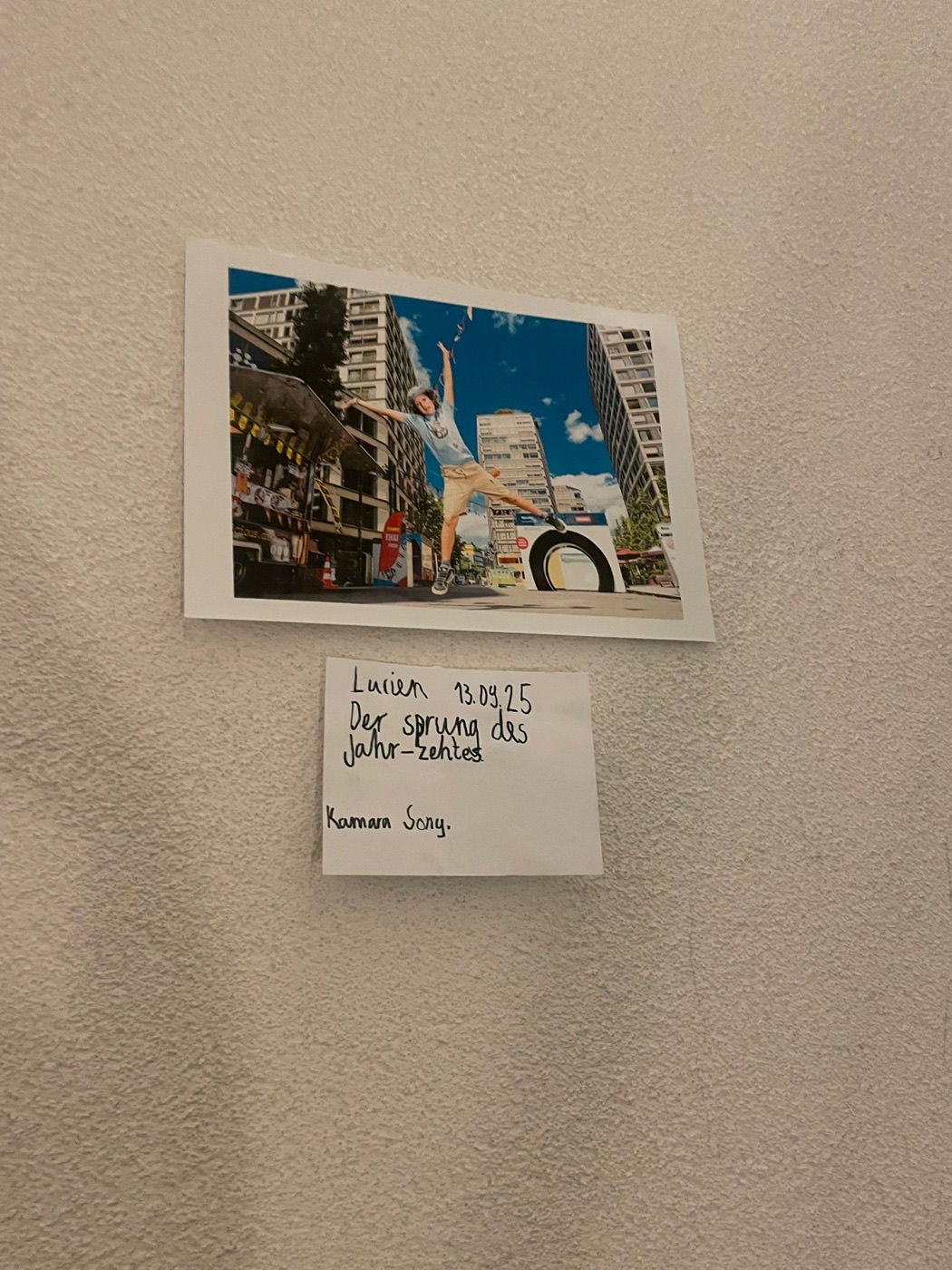 Ein Foto hängt an der Wand, daneben ein handgeschriebenes Kärtchen